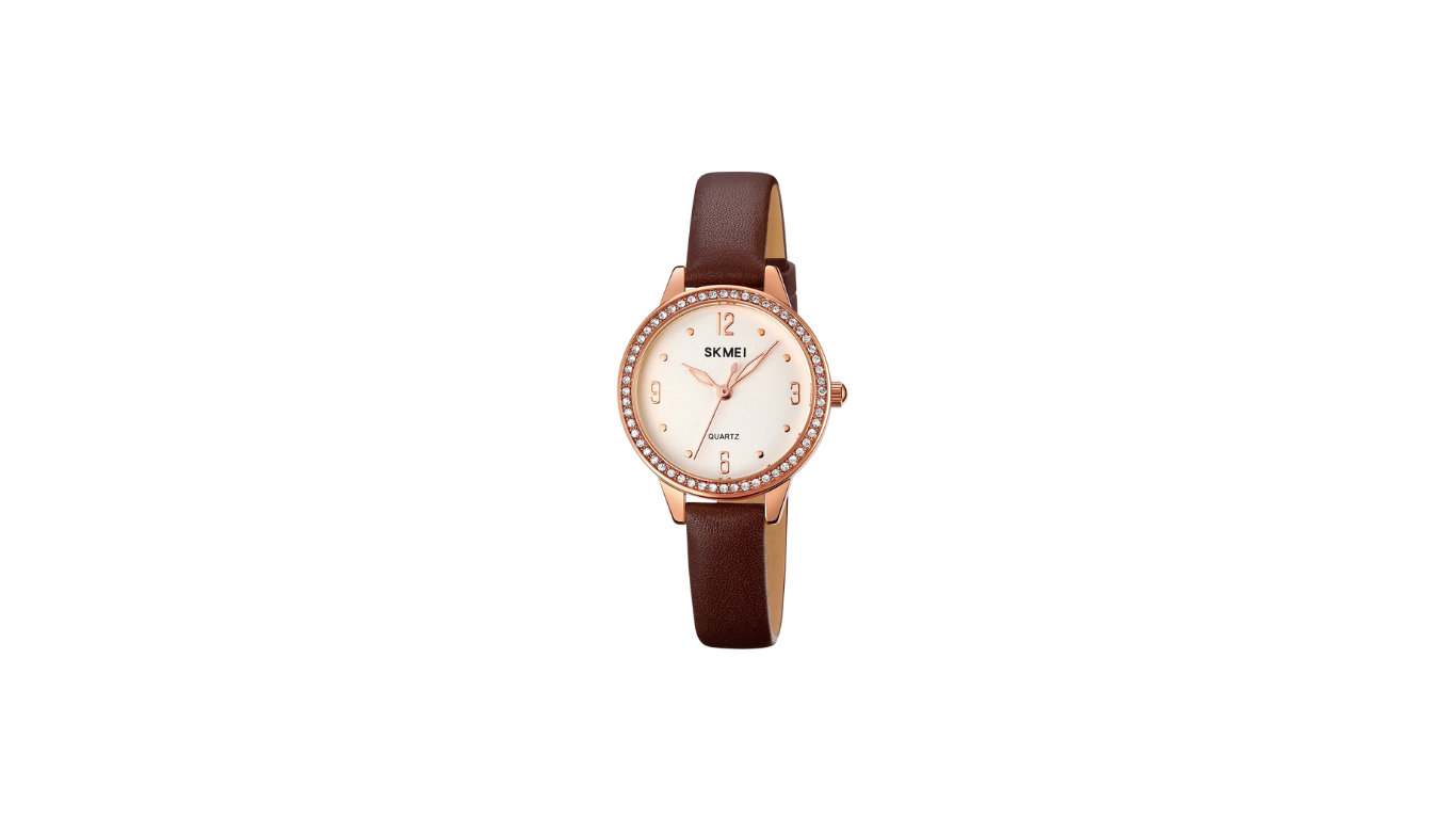 Untitled design (1) SKMEI 2027 women's analog quartz watch, featuring a rose gold-tone case with crystal accents around the bezel and a brown leather strap. - Image 1
